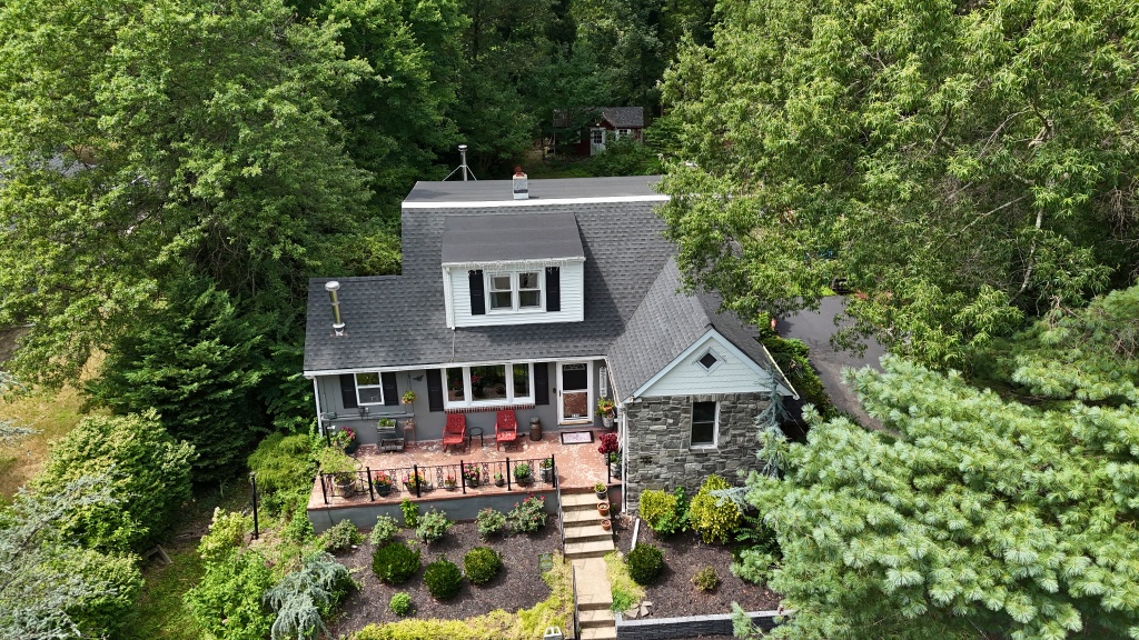 Aerial view of charming cottage home with new gray shingle roof