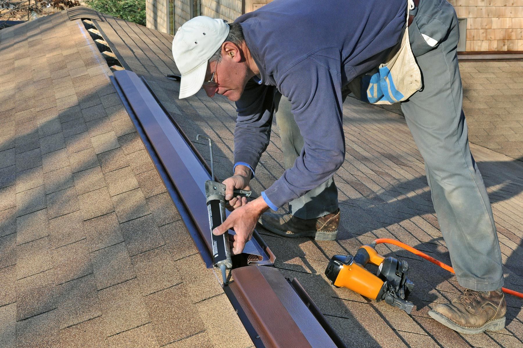 Roofer installing ridge vent for proper attic ventilation